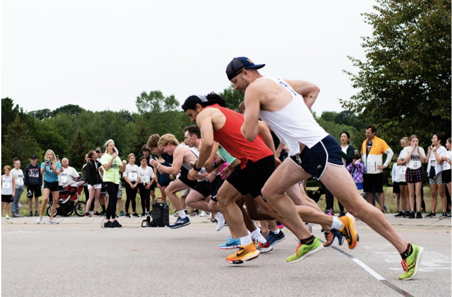 Runners at the starting line of a race with spectators watching.